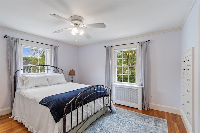 14 Glendale Ave, Melrose, MA 02176 - bedroom with radiator heating unit, multiple windows, baseboards, wood finished floors, and crown molding
