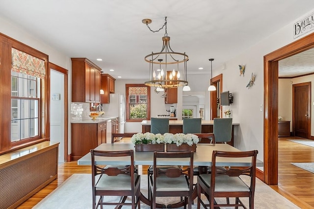 14 Glendale Ave, Melrose, MA 02176 - dining room with radiator heating unit, light wood-style flooring, recessed lighting, baseboards, and a chandelier