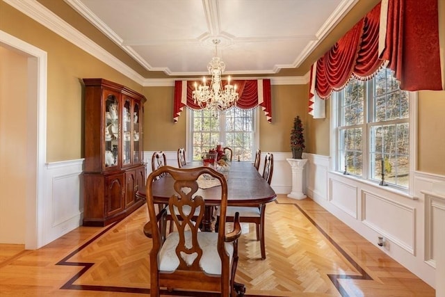 dining area featuring light parquet flooring, an inviting chandelier, and ornamental molding