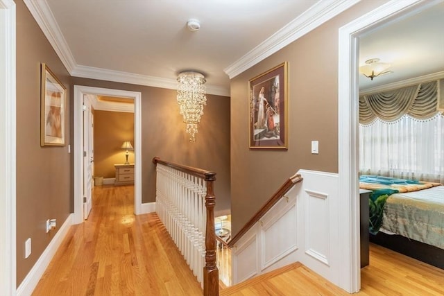 hallway featuring light wood-type flooring and ornamental molding