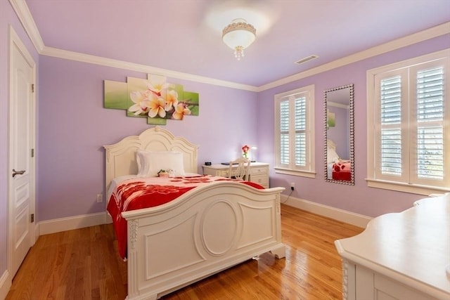 bedroom featuring light hardwood / wood-style floors and crown molding