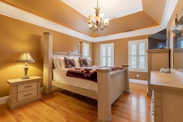 bedroom with a notable chandelier, a raised ceiling, crown molding, and light hardwood / wood-style flooring