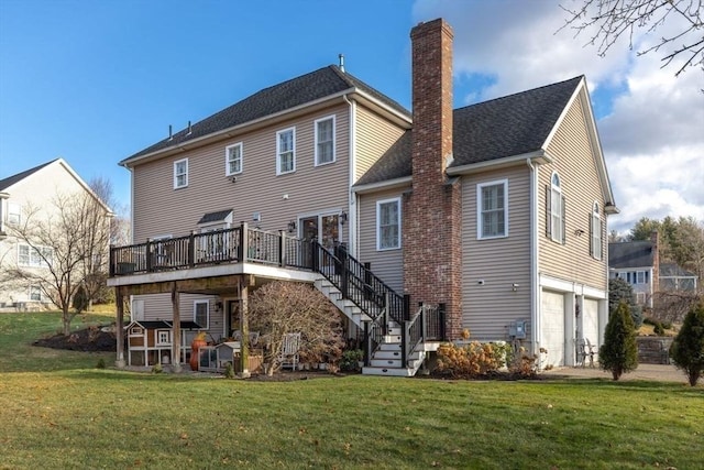 back of property featuring a wooden deck, a yard, and a garage