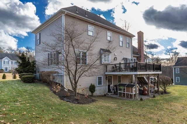 rear view of property with a lawn and a wooden deck