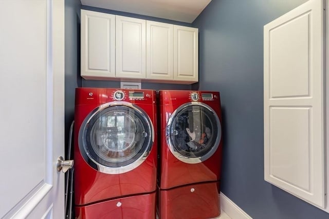 laundry room with separate washer and dryer and cabinets