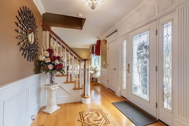 entrance foyer with hardwood / wood-style flooring, plenty of natural light, and ornamental molding