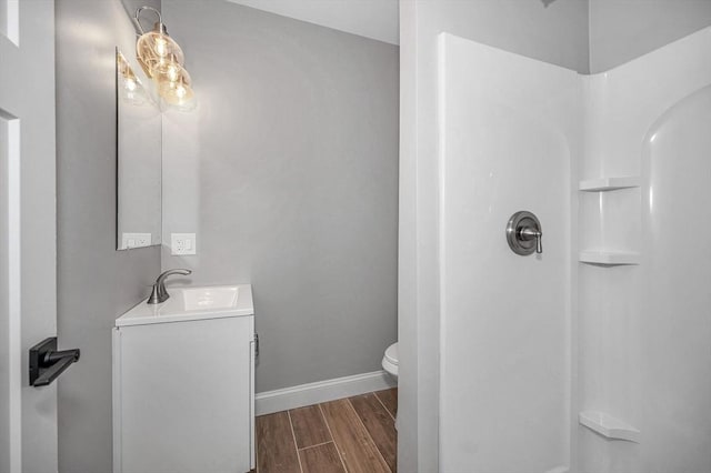 bathroom featuring vanity, toilet, hardwood / wood-style floors, and a shower