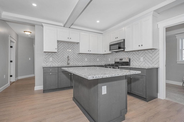 kitchen with white cabinetry, gray cabinets, stainless steel appliances, and a kitchen island