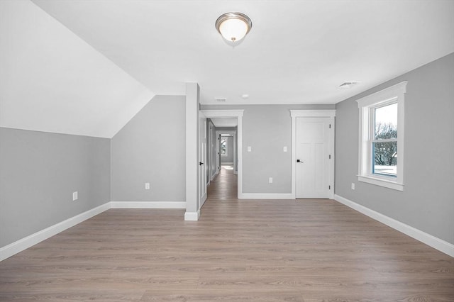 bonus room with vaulted ceiling and light hardwood / wood-style flooring