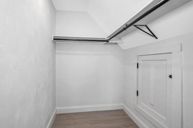 walk in closet with lofted ceiling and hardwood / wood-style flooring