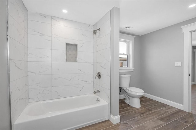 bathroom featuring toilet and tiled shower / bath combo