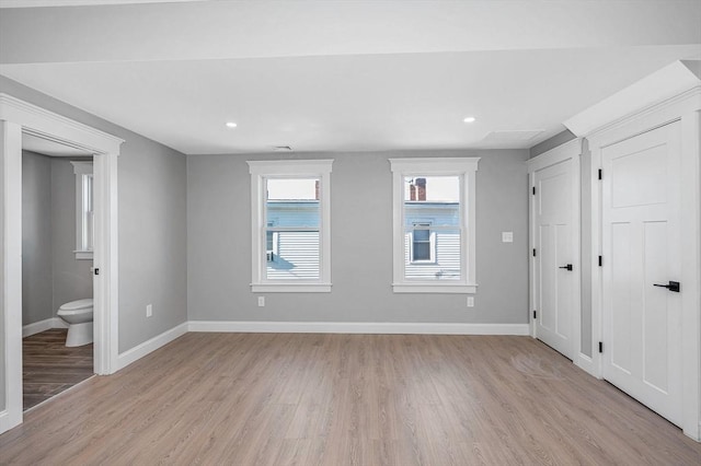 unfurnished bedroom with connected bathroom and light hardwood / wood-style flooring