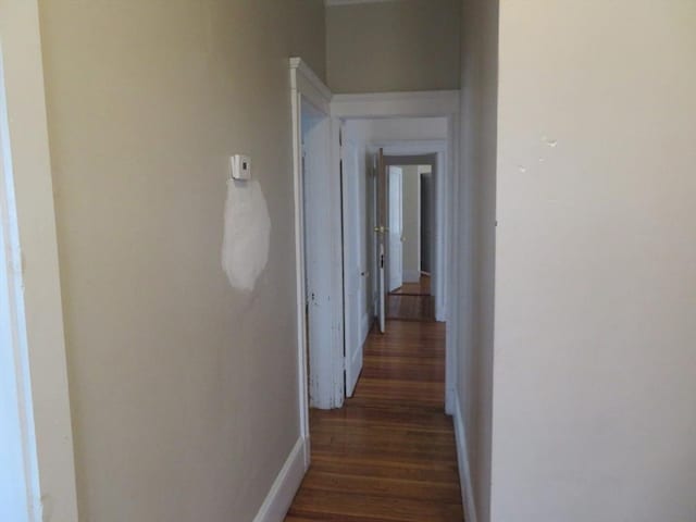 hall featuring baseboards and wood finished floors