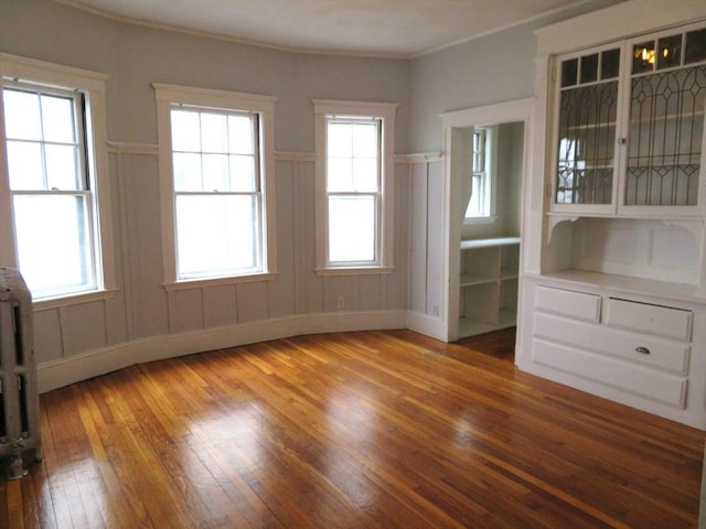 spare room featuring radiator, crown molding, and hardwood / wood-style flooring