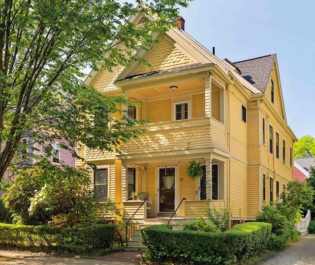 31 Kidder Ave Unit 31, Somerville, MA 02144 - view of front facade featuring covered porch, roof with shingles, and a chimney