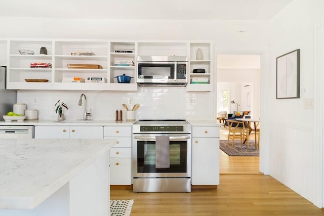 31 Kidder Ave Unit 31, Somerville, MA 02144 - kitchen with appliances with stainless steel finishes, open shelves, a sink, and decorative backsplash