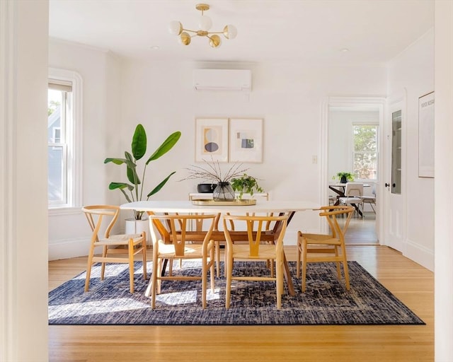31 Kidder Ave Unit 31, Somerville, MA 02144 - dining space featuring a wall unit AC, wood finished floors, baseboards, and a chandelier