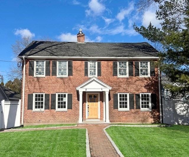 colonial home with a front lawn