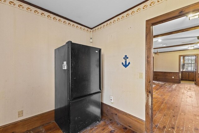 interior space with black fridge, ceiling fan, and hardwood / wood-style floors