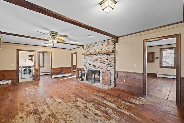 unfurnished living room with a baseboard heating unit, washing machine and dryer, and dark hardwood / wood-style floors