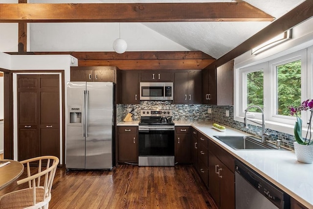 kitchen with lofted ceiling with beams, dark brown cabinetry, a sink, light countertops, and appliances with stainless steel finishes