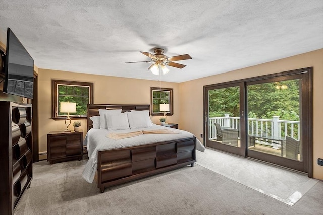 bedroom featuring access to outside, light carpet, ceiling fan, and a textured ceiling