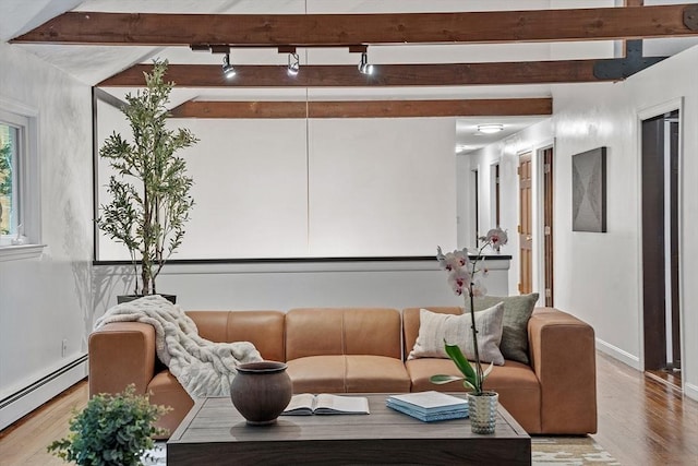 living room featuring rail lighting, baseboard heating, wood finished floors, beamed ceiling, and baseboards