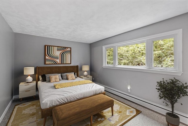 bedroom featuring a baseboard heating unit, multiple windows, and baseboards