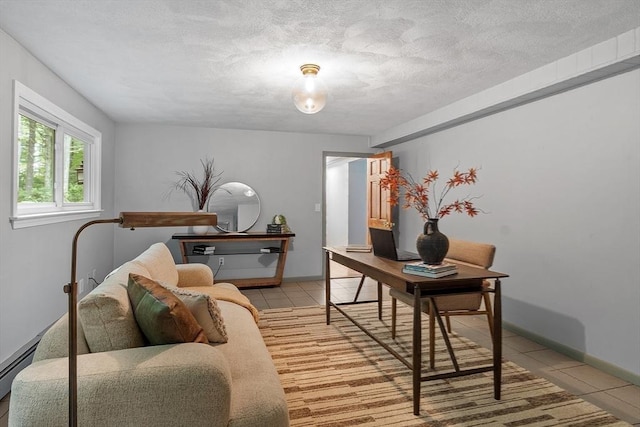 office space with light tile patterned floors, a textured ceiling, baseboard heating, and baseboards