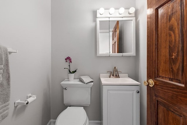 half bathroom with vanity and toilet