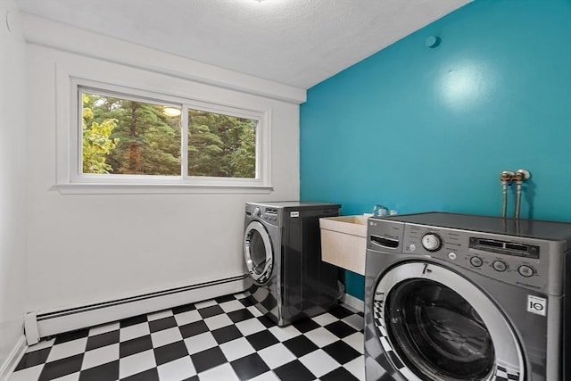 laundry area with a baseboard radiator, laundry area, independent washer and dryer, baseboards, and tile patterned floors