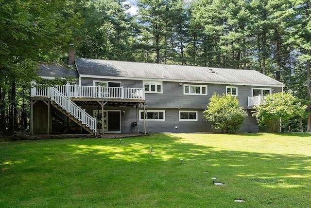 rear view of house with a chimney, stairway, a lawn, and a wooden deck