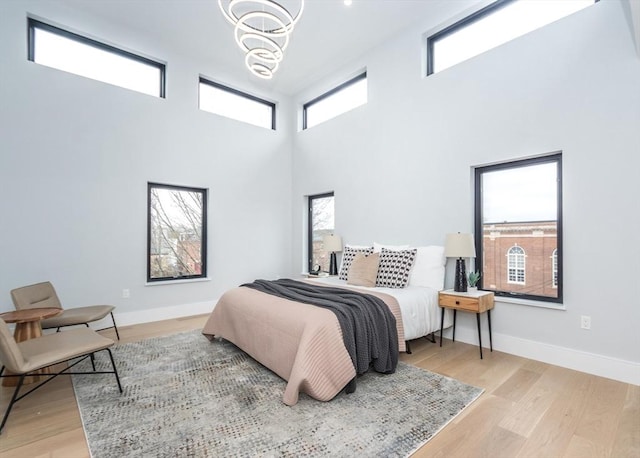 15 Alder St Unit A, Waltham, MA 02453 - bedroom featuring a chandelier, a towering ceiling, and light wood-style flooring