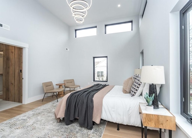 15 Alder St Unit A, Waltham, MA 02453 - bedroom with a high ceiling, wood finished floors, and a chandelier