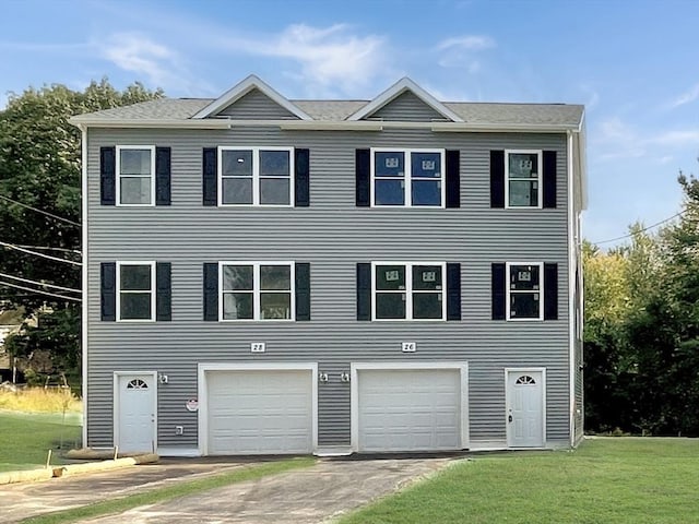 view of front facade featuring a garage, driveway, and a front yard