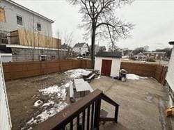 view of patio with an outbuilding, fence, and a storage unit