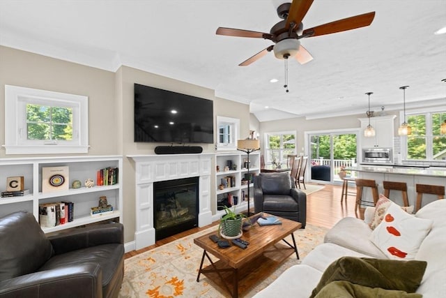 260 Beaver Dam Rd, Scituate, MA 02066 - living room with light wood finished floors, crown molding, ceiling fan, a glass covered fireplace, and recessed lighting