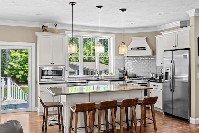 260 Beaver Dam Rd, Scituate, MA 02066 - kitchen with appliances with stainless steel finishes, custom range hood, decorative backsplash, dark countertops, and wood finished floors
