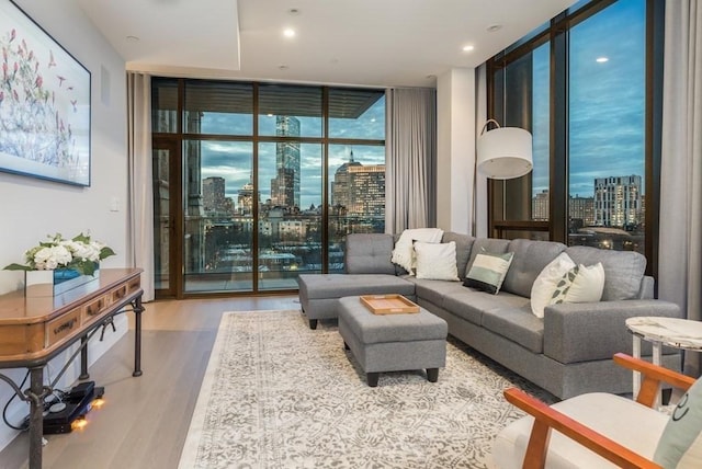 living area featuring light wood-type flooring, floor to ceiling windows, and a city view