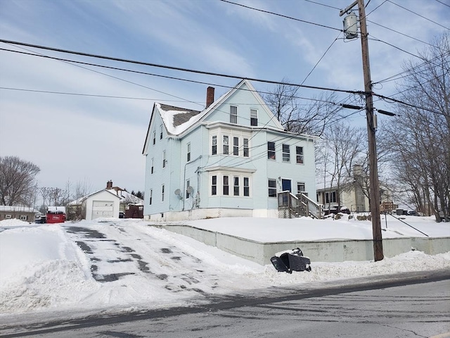 view of front of home with a garage and an outbuilding