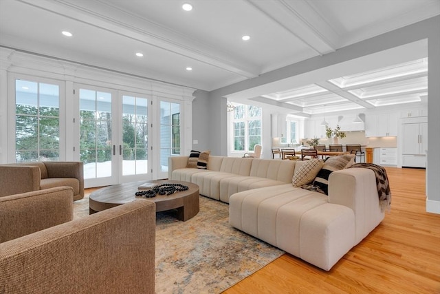 living room with light wood-type flooring, plenty of natural light, and beamed ceiling