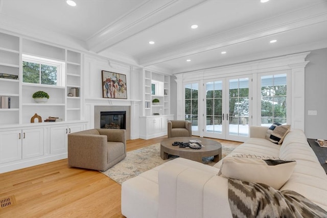 living room featuring light wood finished floors, french doors, plenty of natural light, and ornamental molding