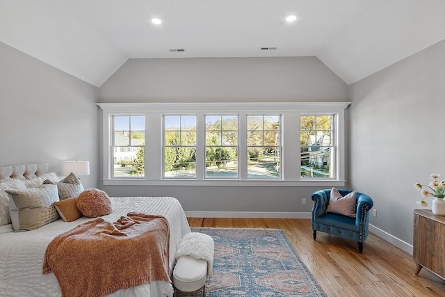 bedroom with visible vents, vaulted ceiling, light wood-style flooring, and baseboards