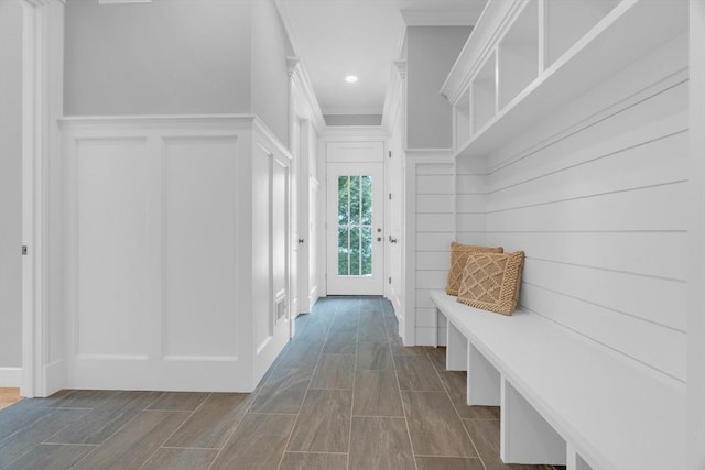 mudroom with crown molding, recessed lighting, and a decorative wall