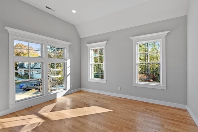 spare room featuring light wood finished floors, recessed lighting, visible vents, vaulted ceiling, and baseboards