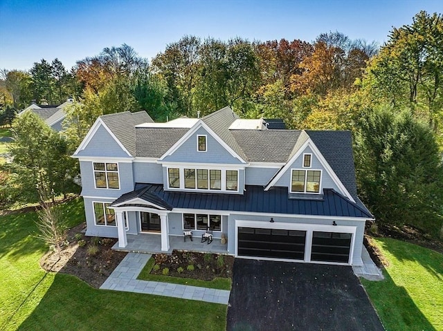 18 Sprague, Wellesley, MA 02481 - view of front of home featuring covered porch, an attached garage, a front yard, a standing seam roof, and driveway