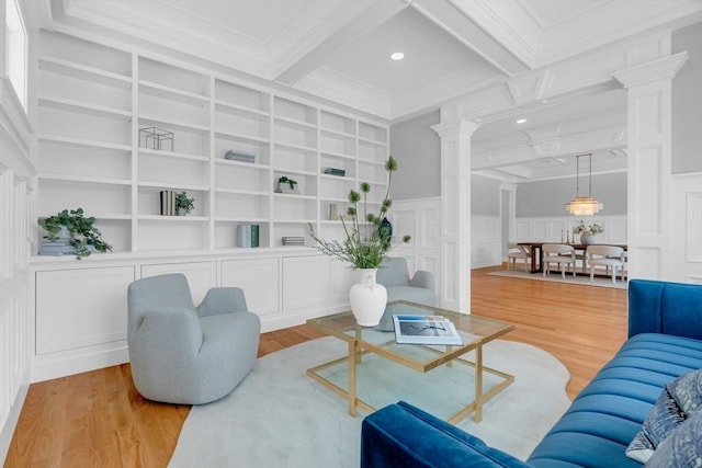 living room with decorative columns, built in shelves, and beam ceiling