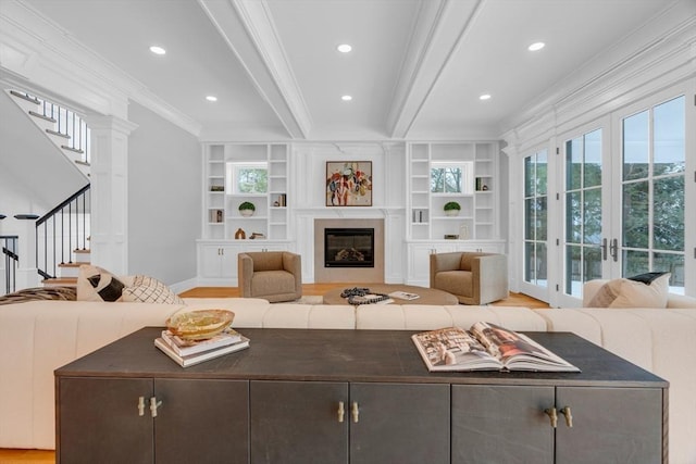 living room featuring built in shelves, recessed lighting, stairway, a premium fireplace, and ornamental molding