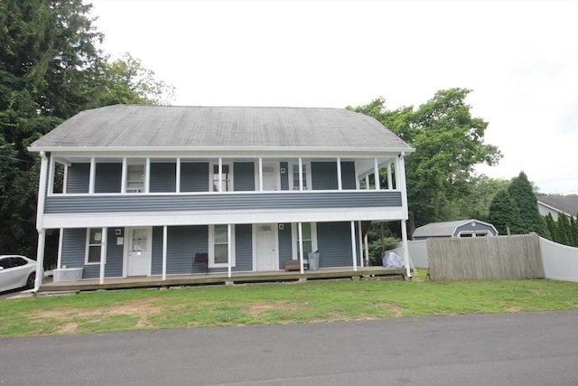 view of front of house with fence, covered porch, and a front yard