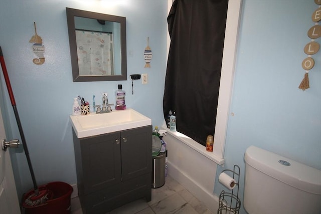 full bathroom with toilet, marble finish floor, and vanity